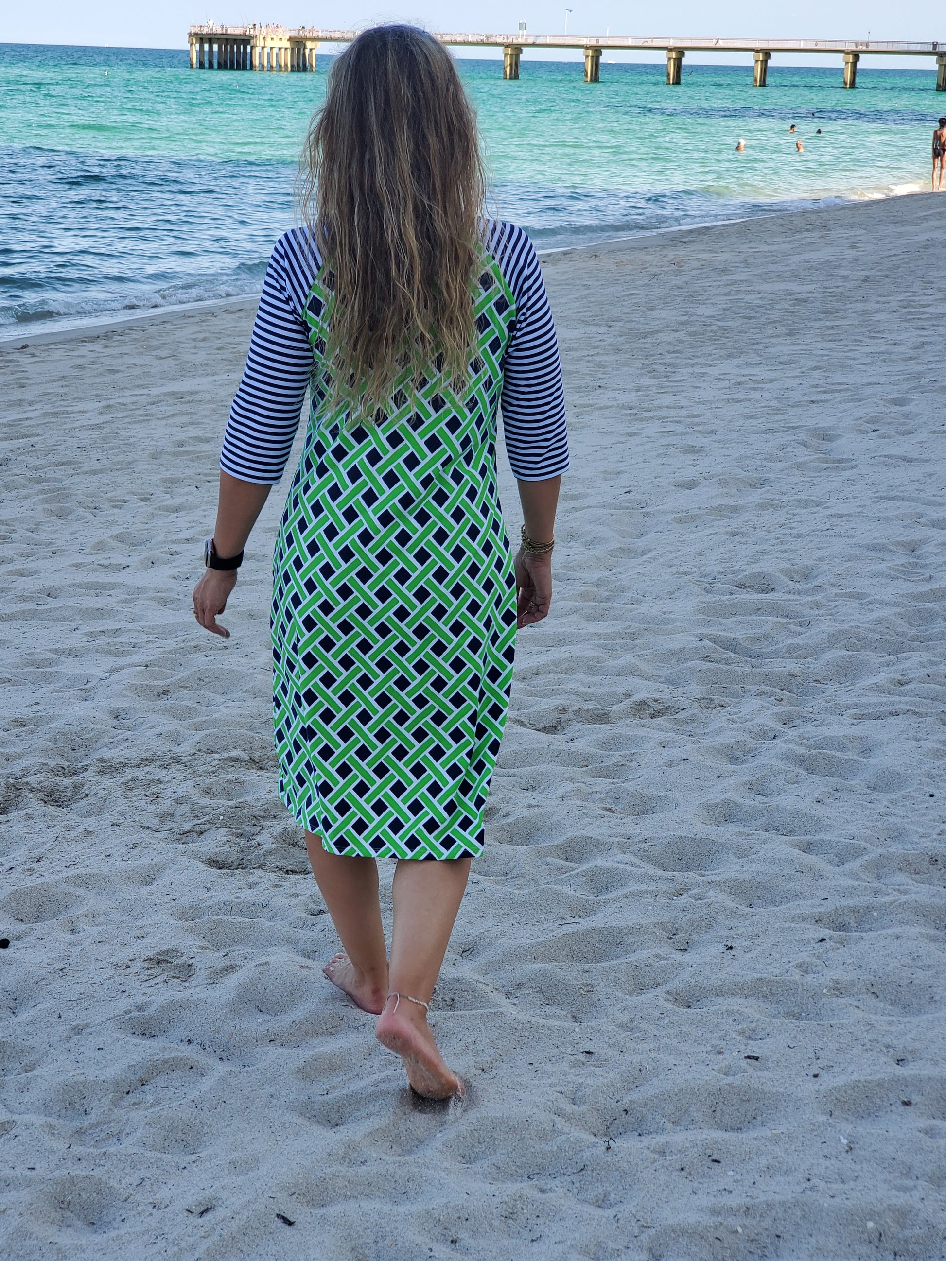 back view of womans modest swimdress in neon green and navy blue print with 3/4 inch sleeves